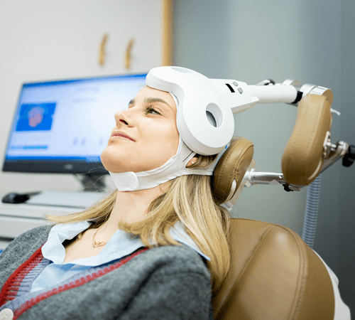 Photo of woman undergoing transcranial magnetic stimulation (TMS) treatment for fibromyalgia.