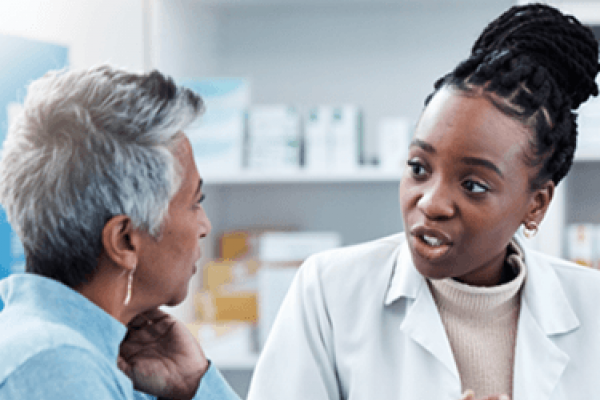 Photo of person talking to a pharmacist about treatments,